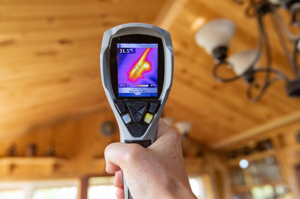 Thermal imaging camera detecting energy loss and air leaks in home attic before spray foam insulation installation
